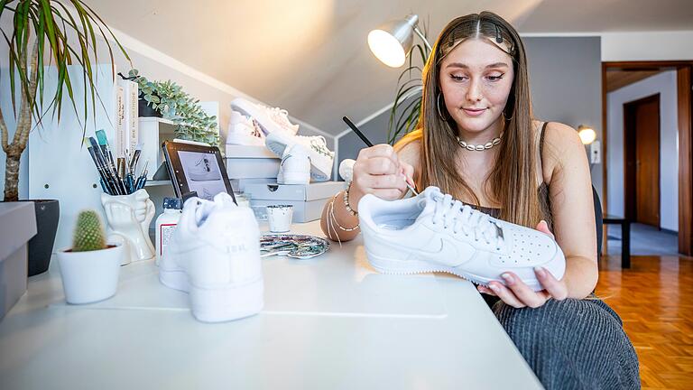 Juliana Haub – hier an ihrem Arbeitsplatz in Münnerstadt – malt seit ihrer Kindheit gerne und kann dabei entspannen. 2020 entdeckte sie die Schuhkunst für sich. Juliana Haub – hier an ihrem Arbeitsplatz in Münnerstadt – malt seit ihrer Kindheit gerne und kann dabei entspannen. 2020 entdeckte sie die Schuhkunst für sich.