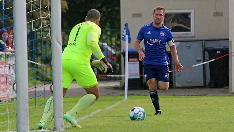 Kapitän Tino Kummer vom TSV Gochsheim (rechts) läuft gegen Marvin Fischer-Vallecilla, den Torwart des TSV Karlburg, vergeblich an.