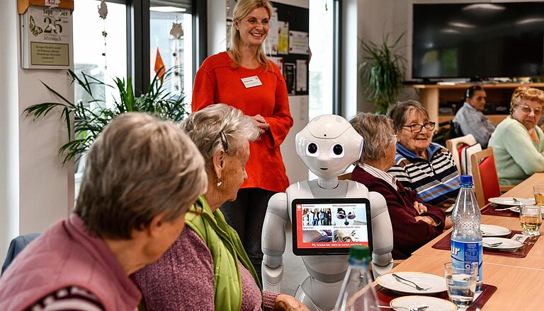 Zwischen 74 und 99 Jahre alt sind die Gäste der Tagespflege in Erlenbach. Trotzdem haben sie keine Scheu im Umgang mit dem kleinen Roboter.