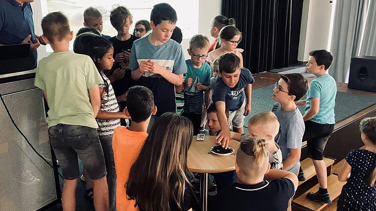 Die Besucherinnen und Besucher der Kinderuni untersuchen Vulkanasche von der Kanareninsel La Palma, auf der es erst im Herbst 2021 zu einem Vulkanausbruch kam.