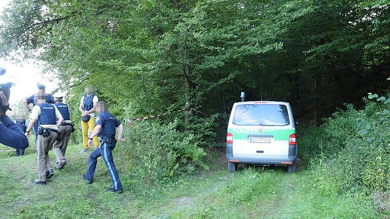 Polizeibeamte machen sich auf den Weg zum Fundort der Leiche im Wald bei Gräfendorf. Polizeibeamte machen sich auf den Weg zum Fundort der Leiche im Wald bei Gräfendorf.