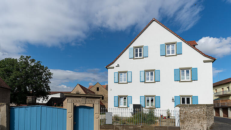 Haussanierung Familie Ruhl in Hergolshausen: Das neugebaute Wohnhaus der Familie Ruhl in der Mainstraße in Hergolshausen mit der Sandsteinpforte und dem Brunnen (rechts neben der Mauer)