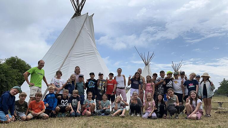 Die Kinder der vierten Klassen und ihre LehrerInnen und Betreuerin der Grundschule Hellmitzheimer Bucht bei ihrem Zeltlager im Tierpark Sommerhausen posieren vor einem Indianer-Tipi, das als Unterkunft diente.