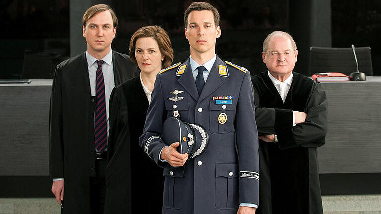 Eurofighter-Pilot Lars Koch (Florian David Fitz, vorne), sen Verteidiger (Lars Eidinger, l), die Staatsanwältin (Martina Gedeck) und der Richter (Burghart Klaußner, r) in &bdquo;Terror - Ihr Urteil&rdquo;.