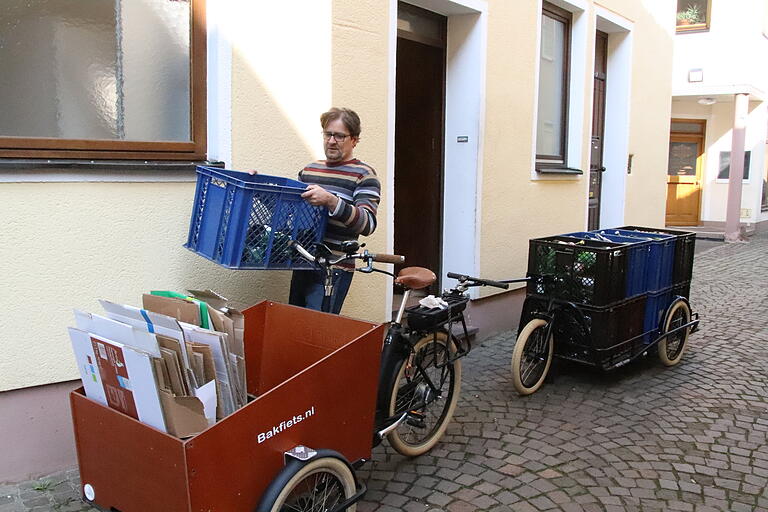Weinwirt Matthias Mehling beim Beladen: auf dem Hänger haben acht Kisten mit Leergut Platz. In der Ladekiste am Fahrrad bringt er bequem Kartonagen und Weißblech unter. Weinwirt Matthias Mehling beim Beladen: auf dem Hänger haben acht Kisten mit Leergut Platz. In der Ladekiste am Fahrrad bringt er bequem Kartonagen und Weißblech unter.