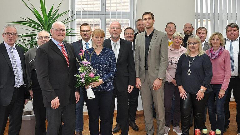 Werner Mock (Bildmitte mit Ehefrau Sieglinde) geht nach 48 Dienstjahren in den Ruhestand. Bürgermeister Wolfgang Borst (vorne, Erster von links) und VG-Leiter Andreas Dellert (vorne, Vierter von links) sowie die Bürgermeister der VG Hofheim und Mocks Kollegen kamen zur Verabschiedung ins Bürgerzentrum.