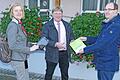 Stadträtin Anita Spinner und Ortsvorsteher Peter Renner bekamen von Bürgermeister Lukas Braun eine kleine Tafel mit der Aufschrift 'Hier funkt's!' überreicht, die auf den WLAN-Hotspot im Bürgerhaus von Deubach aufmerksam macht.
