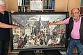 Carl Spitzweg trifft Friedrich Rückert       -  (oli)   Eine Idee wurde Wirklichkeit: Die Schweinfurter Werner Hafner (links) und Gerhard Stahl hatten vergangenes Jahr die Idee zu einer neuen Bildkomposition, &bdquo;Spitzweg trifft Rückert&ldquo;. Hafner kam nach einem Museumsbesuch in Holland inspiriert von den Bilderwelten Hieronymus Boschs zurück, sein Freund Gerhard Stahl, einst Kunsterzieher, als Maler und Zeichner tätig sowie seit Jahren Aufsicht im Museum Georg Schäfer, einem der größten Spitzweg-Museen der Welt, war begeistert von der Idee und setzte sie um. Grundlage für das 140 mal 90 Zentimeter große Bild in Acryl auf Leinwand ist der Schweinfurter Marktplatz rund um das Rückert-Denkmal, das aus kompositorischen Gründen gedreht werden musste, genauso wie Stahl nur das historische Rathaus und nicht den Ämterbau malte. In diese Komposition baute Stahl Figuren aus Spitzwegschen Hauptwerken ein, er gab ihnen &bdquo;Urlaub&ldquo; auf dem Schweinfurter Marktplatz. Scheinbar zufällig finden sich nun der arme Poet, der Bibliothekar oder die diskutierenden Mönche rund um das Rückert-Denkmal, als seien sie Teil Schweinfurts. Das Ergebnis kann sich durchaus sehen lassen. Stahl, der viel Zeit auch in die Bild- und Figurenrecherche im Vorfeld gesteckt hat, sieht das Bild als Reminiszenz an einen bedeutenden Künstler. Er hat von seinem Werk ein 60 mal 80 Zentimeter großes Poster in einer Auflage von 500 Stück machen lassen, das in der Museumsbuchhandlung des MGS ab 2. Juli im Rahmen der &bdquo;Spitz und Knitz&ldquo;-Ausstellung sowie weiteren Verkaufsstellen in der Stadt angeboten wird.