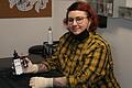 Madlen Wittmann, Inhaberin des Tattoostudios Nadel NESt in Bad Neustadt, an ihrem Arbeitsplatz im Keller des Studios. In der Hand hält sie die Tattoo-Farben Schwarz und Rot, die sie hauptsächlich für ihre Arbeit benutzt.
