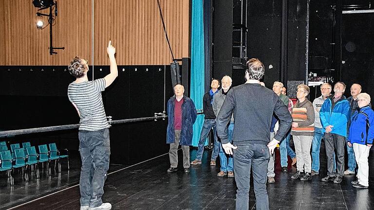 Einen Blick hinter die Kulissen gewährte Stefan Müller, der technische Leiter der Stadthalle Lohr. Auf dem Bild erläutert er den Besuchern auf der Bühne den türkisfarbenen Bühnenvorhang.