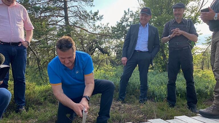 Zupackend beim symbolischen Nageleinschlag für den neuen Bohlensteg des Schwarzen Moores. Im Bild (v. links) Michael Geier (Leiter Bayerische Verwaltungsstelle Biosphärenreservat Rhön), Martin Neumeyer (Vorstandsvorsitzender Bayerische Staatsforsten), Landrat Thomas Habermann, Klaus Spitzl (Geschäftsführer Naturpark und Biosphärenreservat Rhön).&nbsp;