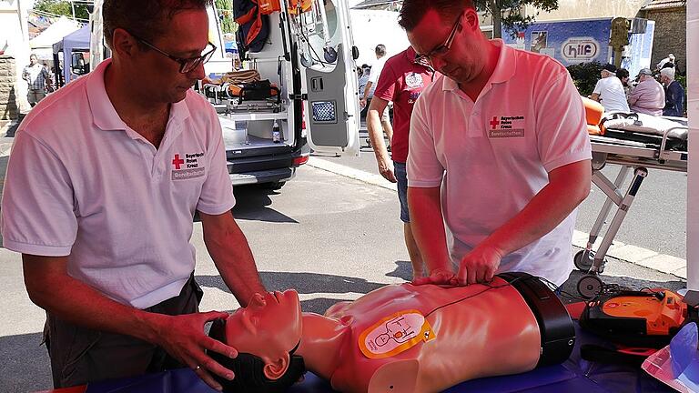 Im Ernstfall zählt jede Minute: BRK-Bereitschaftsleiter Thomas Kossner (links) und Stellvertreter Tobias Teichmann demonstrieren auf dem Schwanfelder Jahrmarkt einen AED.