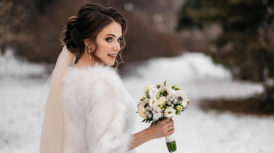 Portrait of a beautiful young woman, bride, in a winter forest       -  Ein Cape oder eine Jacke vervollständigen Ihr Outfit als Winterbraut.