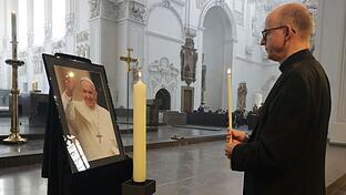 Würzburgs Bischof Franz Jung zündete im Gedenken an den verstorbenen Papst Franziskus am Ostermontag im Kiliansdom eine Kerze an. Auch ein Kondolenzbuch liegt dort aus.
