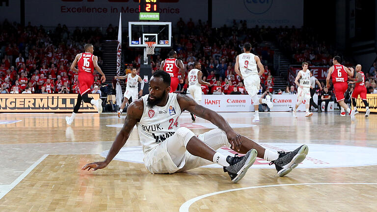 Sinnbild für das Play-off-Aus von s.Oliver Würzburg: der Würzburger Mike Morrison sitzt auf dem Hosenboden, während der nächste Bamberger Angriff läuft.