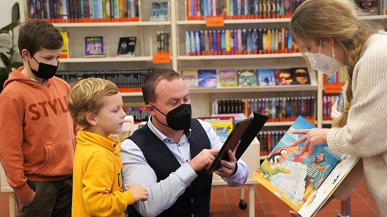Bürgermeister Christian Keller probiert mit Moritz (links) und Oskar das neue Tablet-Lesevergnügen mit App, das die Gemeindebibliothek in Grafenrheinfeld mit Leiterin Anna Scharf ganz neu im Programm hat. Bürgermeister Christian Keller probiert mit Moritz (links) und Oskar das neue Tablet-Lesevergnügen mit App, das die Gemeindebibliothek in Grafenrheinfeld mit Leiterin Anna Scharf ganz neu im Programm hat.