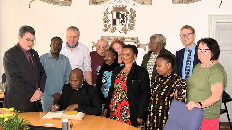 District Pastor Gervas Meitamei trug sich im Beisein von Bürgermeister Wolfgang Lampe (links), der Delegation aus Tansania und von Mitgliedern des Vorbereitungskreises für den Partnerschaftsbesuch ins Goldene Buch der Stadt Uffenheim ein.