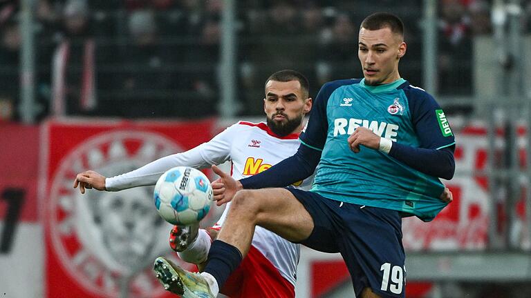 Jahn Regensburg - 1. FC Köln       -  Der Kölner Tim Lemperle (rechts) und Robin Ziegele von Regensburg kämpfen um den Ball.