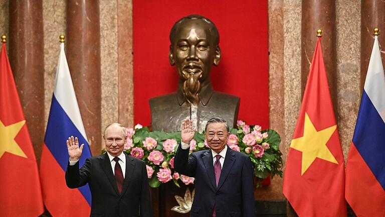 Putin in Vietnam       -  Kremlchef Wladimir Putin (l) und der vietnamesische Präsident To Lam posieren im Präsidentenpalast in Hanoi für die Fotografen.