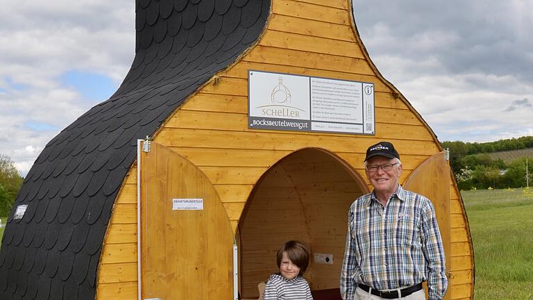 Gemeinsam mit seinem vierjährigen Enkel Lorenz, der schon als „kleiner Weinpoet“ in die Fußstapfen seines Opas tritt, präsentiert Senior-Winzer Gerhard Scheller vom Bocksbeutelweingut in Stammheim stolz sein neuestes Werk. In viermonatiger Handwerksarbeit hat er ein Raumgebilde mit Aufenthaltsqualität in Bocksbeutelform geschaffen. Es ist sicherlich weltweit das erste seiner Art und flexibel einsetzbar. Gemeinsam mit seinem vierjährigen Enkel Lorenz, der schon als „kleiner Weinpoet“ in die Fußstapfen seines Opas tritt, präsentiert Senior-Winzer Gerhard Scheller vom Bocksbeutelweingut in Stammheim stolz sein neuestes Werk. In viermonatiger Handwerksarbeit hat er ein Raumgebilde mit Aufenthaltsqualität in Bocksbeutelform geschaffen. Es ist sicherlich weltweit das erste seiner Art und flexibel einsetzbar.