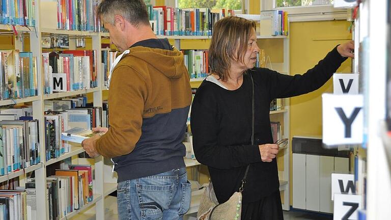 Die Besucher Guido Wendel und Christiane Günther stöbern durch das Angebot der Stadtbücherei.         Foto: Laura-Sophie Lang