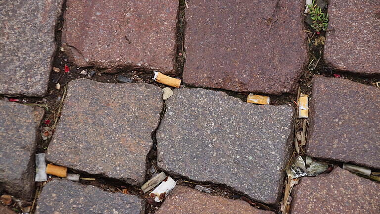 In den Ritzen der Pflastersteine finden sich Zigarettenkippen zuhauf. In den Ritzen der Pflastersteine finden sich Zigarettenkippen zuhauf.