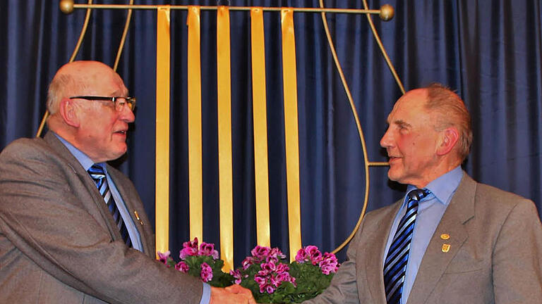 Vorsitzender Georg Riedmann gratuliert Wolfgang Schneider (rechts) zur Goldenen Ehrennadel des Deutschen Chorverbandes.  Foto: Werner Vogel       -  Vorsitzender Georg Riedmann gratuliert Wolfgang Schneider (rechts) zur Goldenen Ehrennadel des Deutschen Chorverbandes.  Foto: Werner Vogel