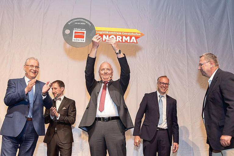 Niederlasssungsleiter Franz Fritzenschaft (Mitte) erhielt den symbolischen Schlüssel für das Logistik-Zentrum. Mit im Bild (von links) Innenminister Joachim Herrmann, Moderator Johannes Keppner, Helmut Seidel, der Vorsitzende der Norma-Stiftung, und Eike Kühn, der Projektleiter der Baufirma Köster. Niederlasssungsleiter Franz Fritzenschaft (Mitte) erhielt den symbolischen Schlüssel für das Logistik-Zentrum. Mit im Bild (von links) Innenminister Joachim Herrmann, Moderator Johannes Keppner, Helmut Seidel, der Vorsitzende der Norma-Stiftung, und Eike Kühn, der Projektleiter der Baufirma Köster.