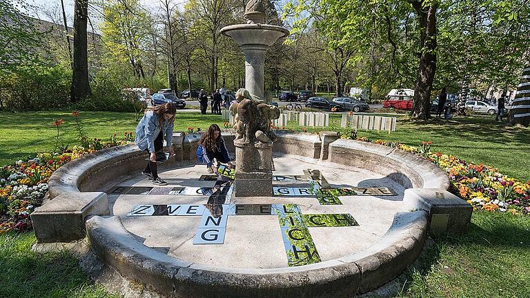 Schülerinnen legen im Ruschkewitz-Brunnen Spiegelscheiben mit Worten aus Amichai-Gedichten aus. In den Glasplatten spiegelt sich die umgebende Natur. Schülerinnen legen im Ruschkewitz-Brunnen Spiegelscheiben mit Worten aus Amichai-Gedichten aus. In den Glasplatten spiegelt sich die umgebende Natur.