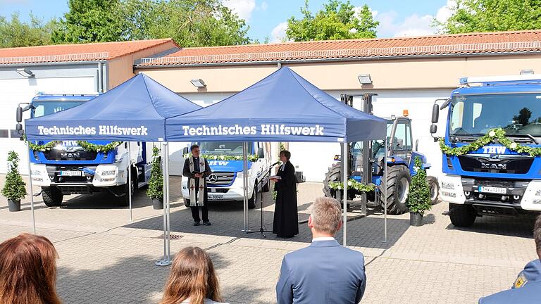 Pfarrer Simon Mayer und Pfarrerin Eva Thelen weihen die neuen Frahrzeuge im THW Ortsverband Karlstadt.