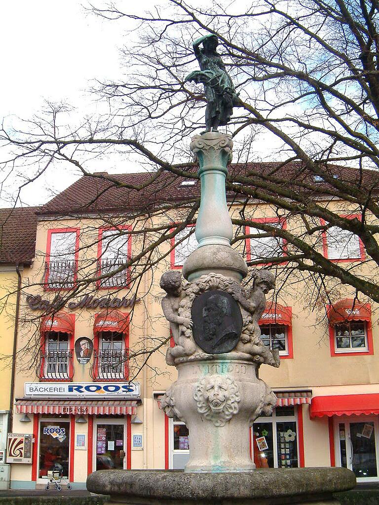 Der Luitpoldbrunnen in Bad Königshofen in unseren Tagen mit einem Portrait des Prinzregenten Luitpold.