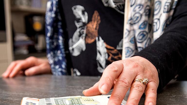 Eine Person greift nach Geldscheinen.jpeg - Rentner sollen einen Steuerbonus bekommen und zwar dann, wenn sie länger arbeiten. Eine Person greift nach Geldscheinen.jpeg - Rentner sollen einen Steuerbonus bekommen und zwar dann, wenn sie länger arbeiten.