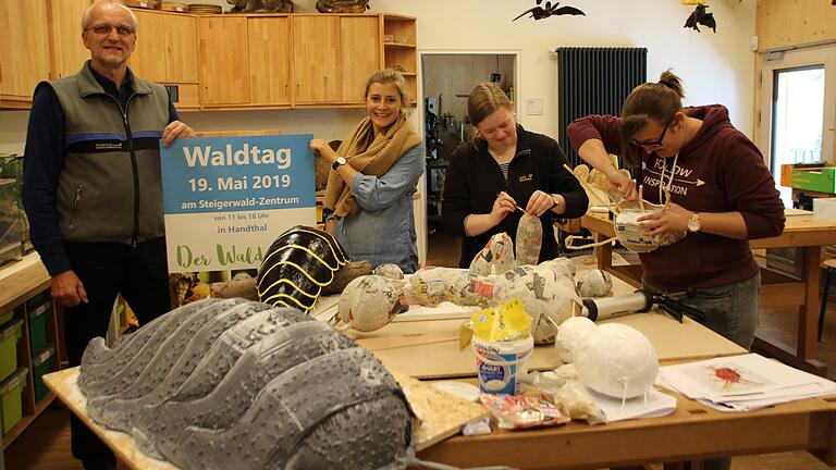 Die Vorbereitungen für den 6. Waldtag laufen auf Hochtouren. Ein großer Programmpunkt ist die Erforschung der Lebewesen im Waldboden. Dafür basteln Leo Paluchin und Katharina Crocell (von rechts) überdimensionale Bodenbewohner wie Asseln und Regenwürmer. Links im Bild der forstliche Leiter des Steigerwald-Zentrums, Andreas Leyrer und Öffentlichkeitsarbeiterin Constanze Stern.