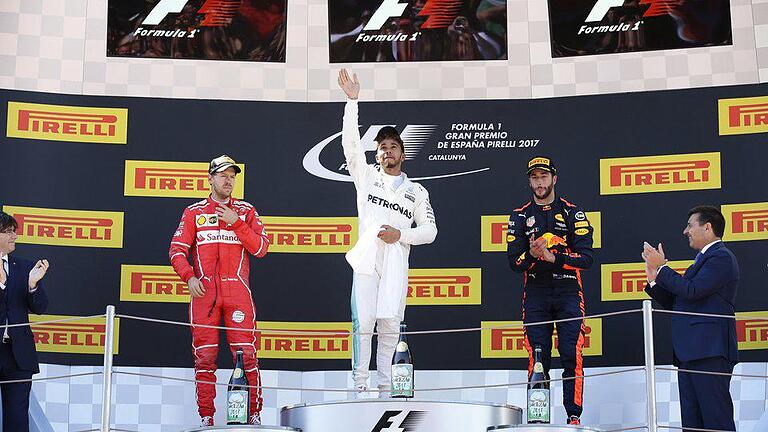 Podium       -  Sieger Lewis Hamilton (M) winkt vom Podium. Links Sebastian Vettel, rechts Daniel Ricciardo. Foto: Manu Fernandez