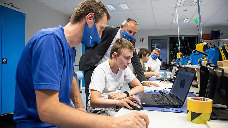 Die Digitalisierung nimmt Fahrt auf in der Wissenswerkstatt: Der zwölfjährige Niklas bei einem Kurs mit einem CAD-Konstruktionsprogramm. Angeleitet wird er dabei von Trainer Markus Dietz (links), während Vorstandsvorsitzender Mario Lory den Design-Entwurf des Hauses begutachtet. An über 70 Wissenswerkstatt-Kursen hat der Junge teilgenommen und wie sein Papa will er später einmal Ingenieur bei Fresenius werden.