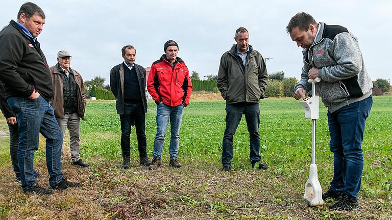 Wie kann man das Nitrat im Grundwasser reduzieren? Landwirte testen auf einem Acker bei Bibergau (Lkr. Kitzingen) einen Spaten, der den Stickstoffgehalt des Bodens messen kann. Mit dabei ist Wolfgang Ehbauer (Dritter von links) von der Regierung von Unterfranken.