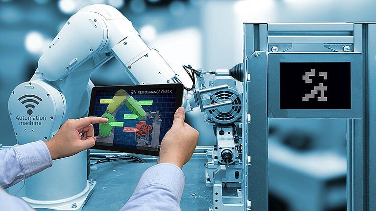 Industry 4.0 concept . Man hand holding tablet with performance check screen software and blue tone of automate wireless Robot arm in smart factory background - „Industrie 4.0“ bedeutet die Vernetzung von Maschinen, aber auch die Vernetzung von Mensch und Roboter. In Schweinfurt sind die Unternehmen mitten im Prozess. Industry 4.0 concept . Man hand holding tablet with performance check screen software and blue tone of automate wireless Robot arm in smart factory background - „Industrie 4.0“ bedeutet die Vernetzung von Maschinen, aber auch die Vernetzung von Mensch und Roboter. In Schweinfurt sind die Unternehmen mitten im Prozess.
