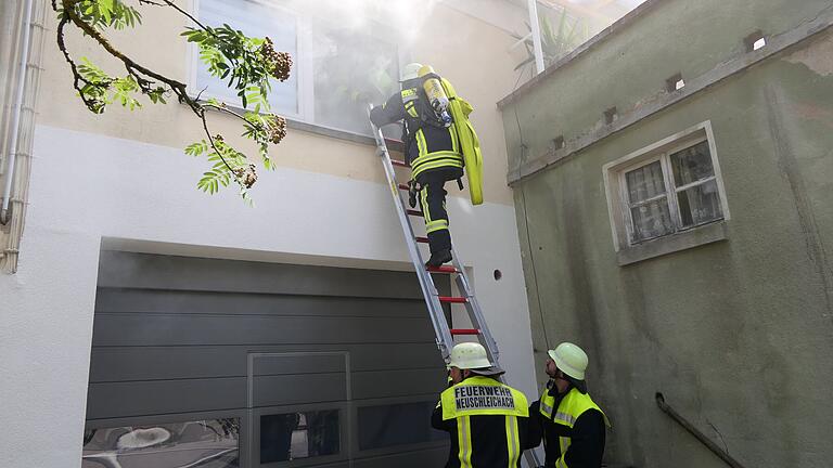 Ein Atemschutzgeräteträger bahnt sich bei der Übung den Weg über eine Leiter zur vermeintlichen Brandwohnung.