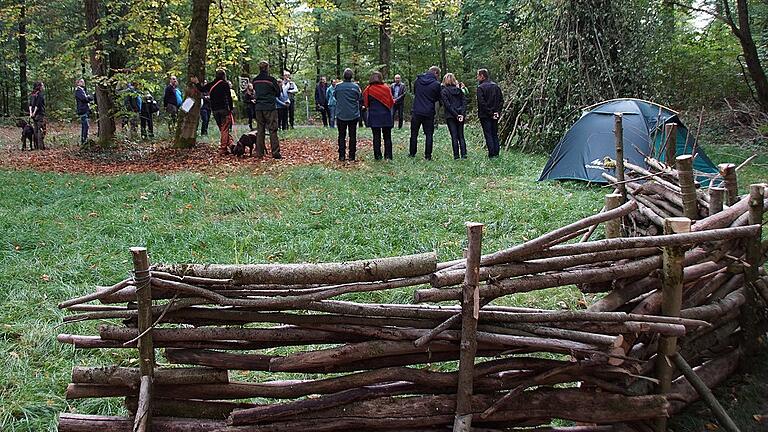 Zur Eröffnung des Trekkingerlebnisses Steigerwald wurden symbolisch am Platz bei Fabrikschleichach auch Elemente anderer Plätze aufgebaut, wie ein Keltenwall (vorne) oder eine Laubhütte (hinter dem Zelt).