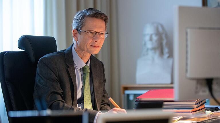 Oberbürgermeister Sebastian Remelé am Schreibtisch in seinem Amtszimmer im Rathaus, im Hintergrund eine Büste von Friedrich Rückert.