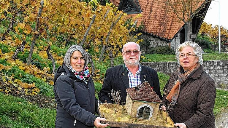 Dritter Heidingsfelder Krippenweg       -  (dz) Schon im Jahr 1699 besaß Heidingsfeld eine Weinbergskapelle, die der Weinlage ihren Namen gab: &bdquo;Würzburger Kirchberg&ldquo;. Im Lauf der Jahre ist sie immer mehr verfallen. 1986 wurde die neue Weinbergskapelle ökumenisch eingeweiht. Anlässlich des Heidingsfelder Krippenwegs im Jahr 2014 hat Jürgen Messerer (Bildmitte) die alte Kapelle nach Bildern und Erzählungen sehr liebevoll und filigran aus Silvesterraketen-Holzstäben, Perlzwiebeln, Trieben der Weintraube und noch mehr Naturmaterial nachgebaut. Zu sehen ist sie beim diesjährigen 3. Heidingsfelder Krippenweg &ndash; vom 1. Advent bis zum Tag der Hl. Drei Könige. Etwa 50 Krippen haben der Verein Heidingsfelder Selbstständige auf dem Bild vertreten durch Eva Ziegler (links) und Hildegard Kram (rechts), sowie die evangelisch-lutherische Kirchengemeinde St. Paul und die katholische Kirchengemeinde St. Laurentius aus Kirchen- und Privatbesitz zusammengestellt. Bewundern kann man sie in der &ndash; Advents- und Weihnachtszeit  &ndash; außer in den Kirchen &ndash; in vielen Schaufenstern entlang der Einkaufsstraßen und auch in manchen Gässchen.FOTO Baumann