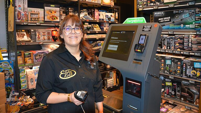 Mitarbeiterin Shoshana Heinikel steht vor einer der beiden SB-Kassen bei Edeka Kolb in Volkach. Hier können die Kunden ihre Produkte selbst scannen und bargeldlos bezahlen.