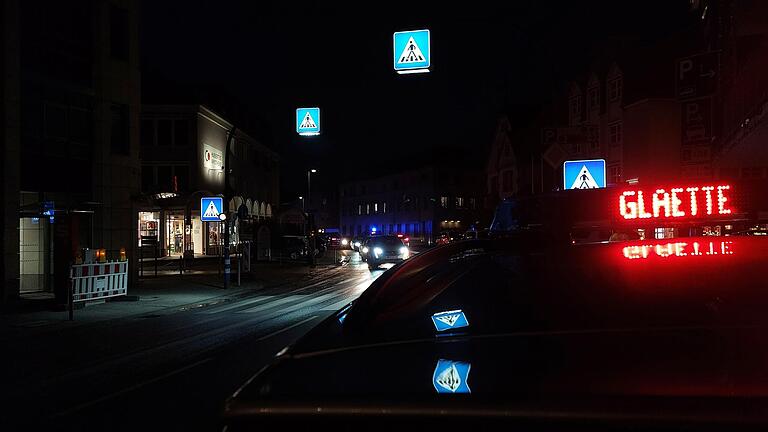 Fahrzeuge der Polizei warnten mit der blinken Aufschrift 'Glätte' vor der Eisschicht.