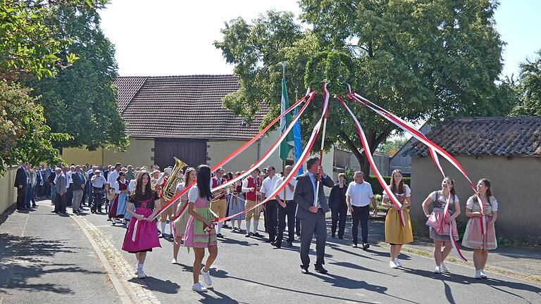 Begleitet von sechs Alitzheimerinnen wurde die Siebenerkrone nach dem Gottesdienst von der Pfarrkirche St. Martin zum DJK-Sportheim getragen, gefolgt von der Alitzheimer Blaskapelle und dem Festzug der Feldgeschworenen.