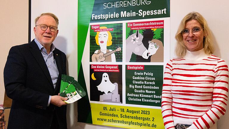 Hans Michelbach, der Verwaltungsratsvorsitzende der gemeinnützigen Festspiel-Gesellschaft, und Geschäftsführerin Bianca Ditterich vor dem Plakat zur Saison 2023 der Scherenburgfestspiele in Gemünden.