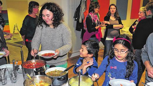 Die Gäste des &bdquo;interkulinarischen Feierabends&ldquo;, einem Projekt der evangelischen Freikirche &bdquo;Vineyard Haßberge&ldquo; im Mehrgenerationenhaus in Haßfurt, ließen sich die angebotenen Eintöpfe schmecken. Im Bild Corina Baishya mit zwei ihrer drei Kinder.
