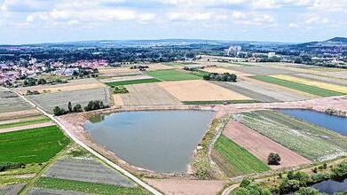 Im Vordergrund die aktuellen Baggerseen nordöstlich von Sand. In der rechten Bildhälfte oberhalb der offenen Wasserflächen soll das neue Sand- und Kiesabbaugebiet entstehen. Etwa dort, wo der von links nach rechts durch die Bildmitte und entlang der Wasserflächen läuft, ist ein Hochwasserdamm geplant.