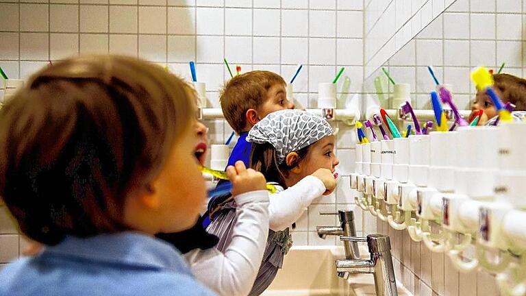 Zähneputzen       -  Am 24. September ist Tag der Zahngesundheit. Unser Symbolbild zeigt Kinder, die in der Wichtel Akademie in München Zähne putzen.