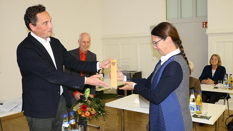 Bürgermeister Mario Paul verabschiedete Christine Kohnle-Weis nach über 13 Jahren aus dem Stadtrat. Statt des bislang obligatorischen Zinntellers der Stadt, gibt es ab sofort ein Erinnerungsstück aus Holz und Glas.