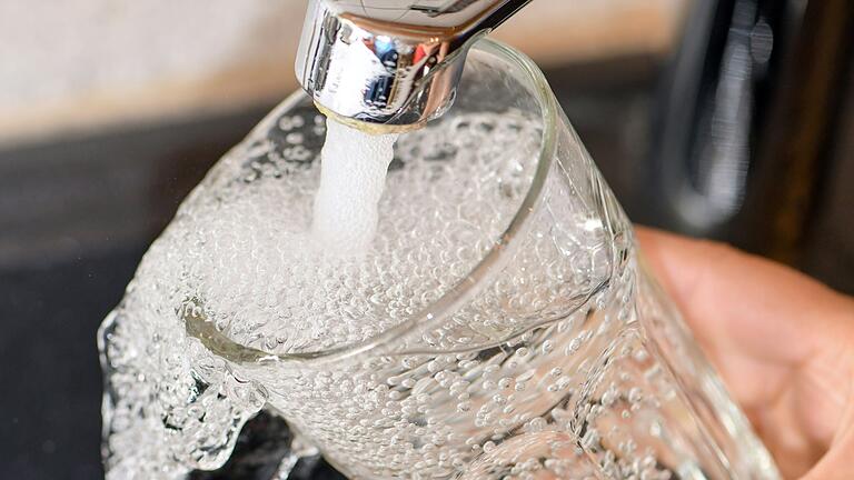 Am Wasserhahn in einer Küche wird ein Trinkglas mit Leitungswasser befüllt. Das ist heute teurer als früher.